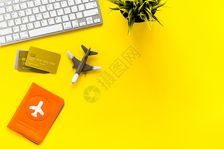 旅行计划 — 护照 键盘 飞机 — 在黄色桌子上自上而下的复印空间图片