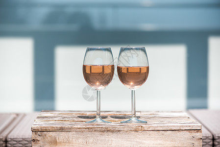 两杯玫瑰红酒 放在一个小木制桌子上 户外 液体图片
