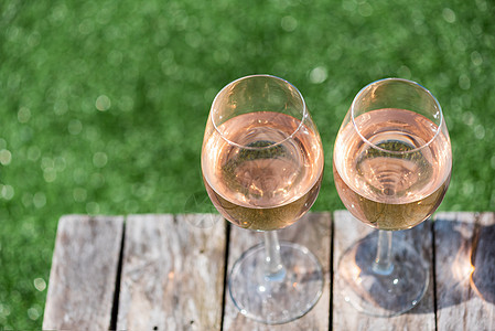 两杯玫瑰红酒放在木制桌上 派对 透明的 酒厂 葡萄酒图片