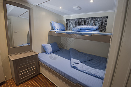 豪华游艇客舱内 床头柜 卧室 双层床 抽屉 木头 舷窗 蓝色的图片