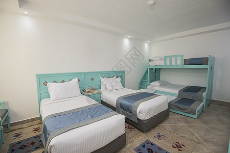 在一个酒店房间豪华家庭房间里的床铺 蓝色的 床垫图片