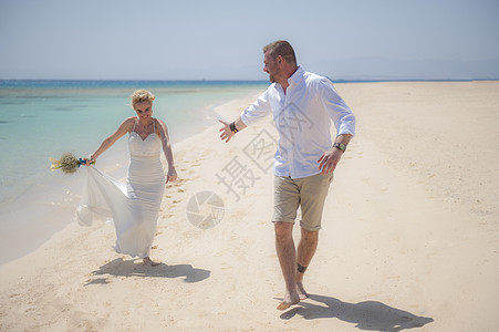 在热带海滩婚礼当天 结婚的一对美丽的夫妻 浪漫 金发女郎图片