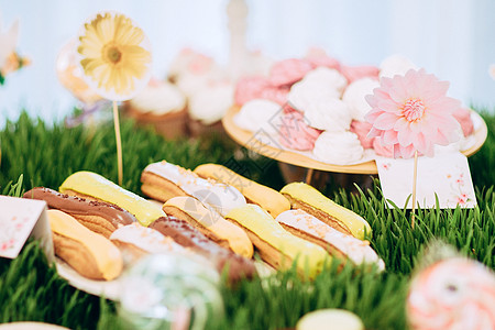 棉花糖和蛋糕放在装饰的糖果棒上的草上图片