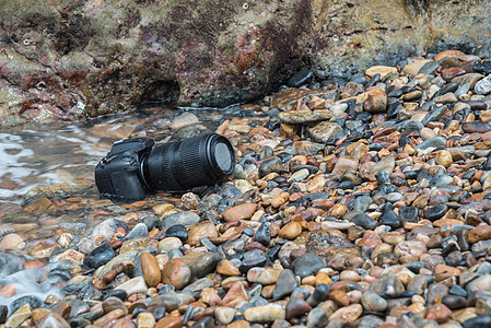 DSLR 在海浪下浸湿的石沙滩上的德国航天中心照相机 信号 镜片图片