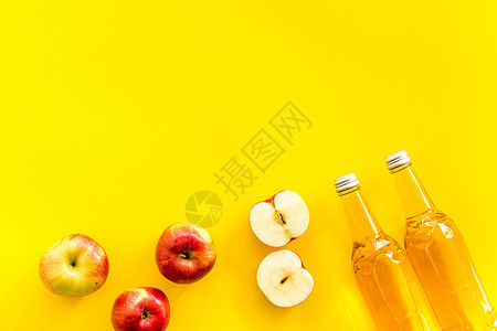 黄色桌面上自上而下文字空间上的苹果苹果苹果醋醋瓶 液体 瓶子背景图片