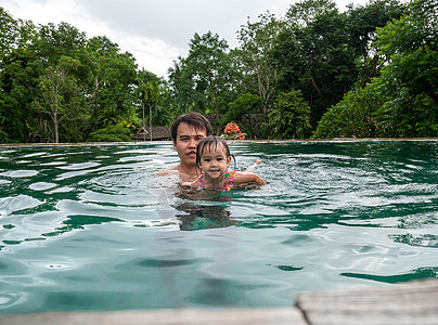 父亲和女儿在泰国北部度假胜地游泳池享受暑假的肖像 注 a 快乐的 健康图片
