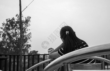 孤单地坐在露台看日落的亚裔年轻女性 夏天 独自的图片