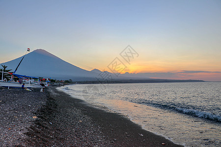 热带岛屿的海滩日落 橙色天空和云彩 地平线上的大火山 宁静的海洋和浪漫的氛围 爬坡道 旅行图片