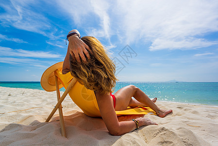 妇女在热带海滩的横轴渡轮上享受节假日 休息室图片
