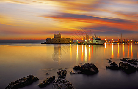 希腊罗得斯曼德拉基港的堡垒 海 日落 城堡图片