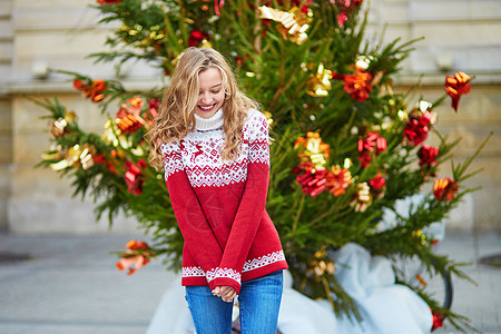 带着一棵明亮装饰的圣诞树的女孩 街道 冬天 法国背景图片