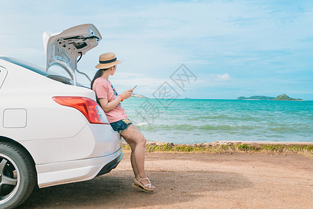 妇女用沙滩车坐着的智能手机图片