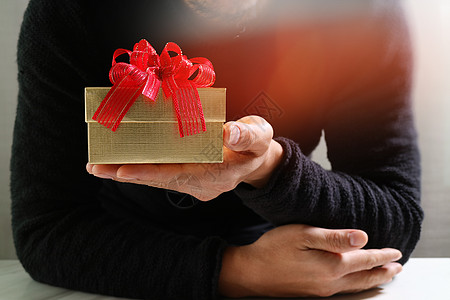 男子手拿着礼物盒作为赠与的表示 b 假期 生日图片