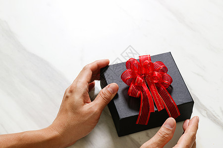 男人手拿着一个礼物盒 作为赠与的表示 快乐的图片