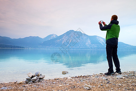 拍下秋山湖风景的照片 高人手握手机 运动员 假期图片