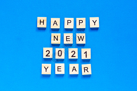 蓝色背景上用木制字母写的新年快乐 2021 年新年快乐 平面布局 文本空间 顶视图 商业 问候语图片