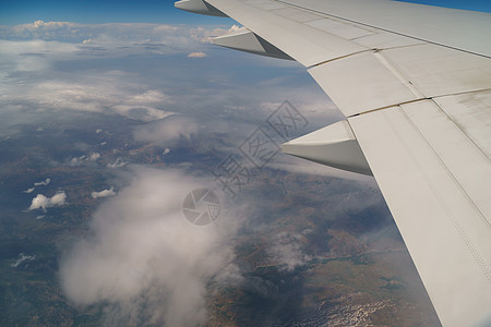 飞行和旅行 在阴天从机翼上的飞机窗户观看 飞机的机翼在清晨的云层之上飞行 高度 天空图片
