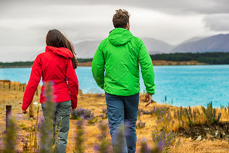 新西兰旅游 — 一对游客在奥拉基附近徒步旅行 欣赏普卡基湖的自然景观 也就是著名的旅游胜地彼得山的库克山图片
