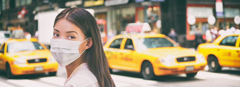 中国女性游客在纽约市街上行走时 身着科罗纳病毒保护外科面罩 疫情蔓延和恐慌 交通计程车的全景横幅背景图案是图片