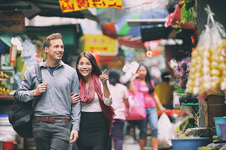异族情侣游客在中国香港的中国市场散步购物 在亚洲旅行的年轻人正在寻找当地的街头食品 亚洲女人 白人男人图片