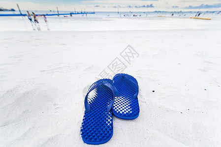 沙滩上的蓝色翻滚轮 沙滩上的凉鞋 脚蹼 拖鞋图片