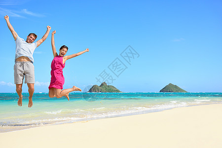 快乐的游玩游客情侣跳上海滩度假图片
