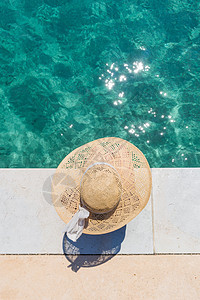 身戴大夏日太阳帽的女人 在明亮的绿绿海边码头放松 棕褐色 游泳衣图片