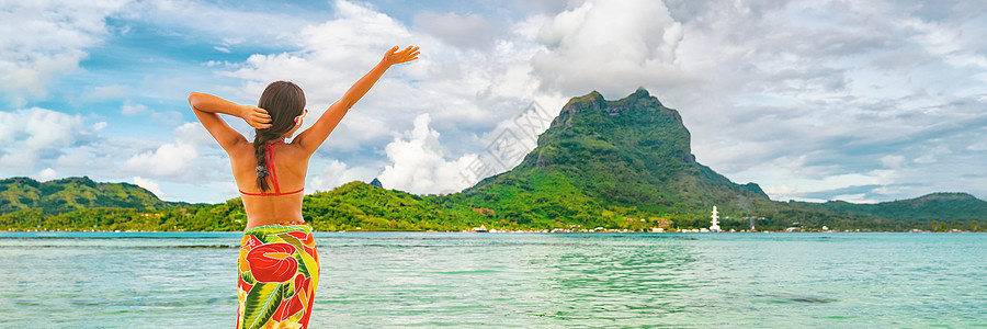快乐的大溪地旅游女性在天堂享受自由假期 法属波利尼西亚草裙舞者在法属波利尼西亚塔希提岛奥特马努山前的波拉波拉海滩上跳舞 横幅全景背景图片