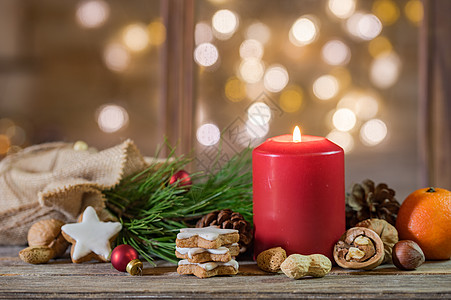 圣诞节假日背景 红蜡烛和灯光模糊的木材上天然装饰品为圣诞假背景图片