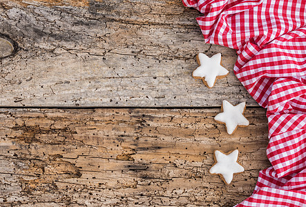 红格形布边和旧木本 复制空间上的圣诞恒星形状的饼干图片