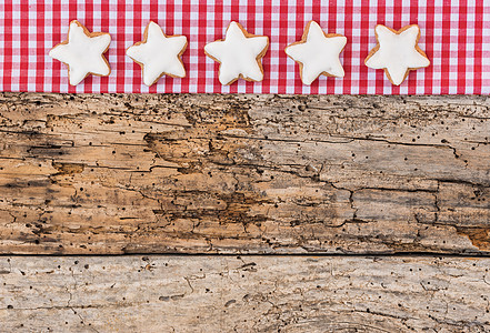 红格形布和旧木本底的圣诞恒星形状饼干边框 复制空间 姜饼 织物图片