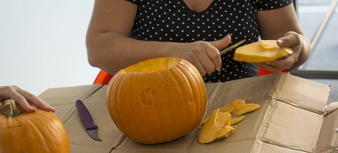 雕刻南瓜制作南瓜灯的过程 为万圣节和感恩节创造传统装饰 切好的橙色南瓜躺在女人手中的桌子上 秋天图片