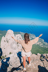 在悬崖海岸边缘的户外旅游女游客 太阳 闲暇 旅行图片