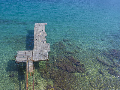 在破旧的木码头上 可以看到爱奥尼亚海 法里拉基海滩 希腊科孚岛的碧蓝海水图片