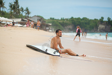 这家伙在冲浪后 正在沙沙热带海滩上休息 在夏季职业中健康活跃的生活方式 水 行动图片