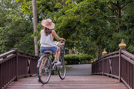 穿着便衣的年轻快乐女青年 享受骑自行车的狂欢时光 旅游 乐趣图片