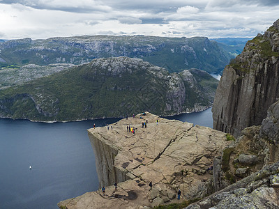 巨大的悬崖在峡湾 Lysefjord 著名的挪威观点与游客和徒步旅行者 喜怒无常的秋日 自然和旅游背景 假期和远足假期的概念 海图片