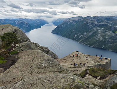 巨大的悬崖在峡湾 Lysefjord 著名的挪威观点与游客和徒步旅行者 喜怒无常的秋日 自然和旅游背景 假期和远足假期的概念 海图片