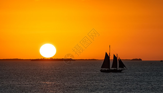 日落时航帆船在西基西海岸边图片