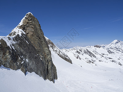 冬季景观与陡峭的山峰和积雪覆盖的斜坡和滑雪道 滑雪者在滑雪胜地 Stubaital 蒂罗尔 奥地利阿尔卑斯山享受春天阳光明媚的日图片