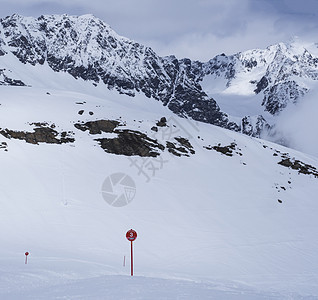 冬季景观与空荡荡的红色滑雪道标志 白雪覆盖的山坡 春天阳光明媚的日子在滑雪胜地 Stubaital 蒂罗尔 奥地利阿尔卑斯山 冰图片