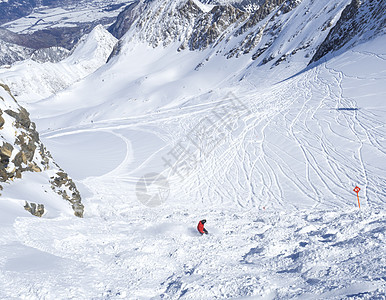 在欧洲奥地利阿尔卑斯山国家公园的 Kaprun 滑雪胜地的山顶 穿着红色衣服的滑雪者在积雪覆盖的斜坡上自由滑雪 阳光明媚的冬日 图片