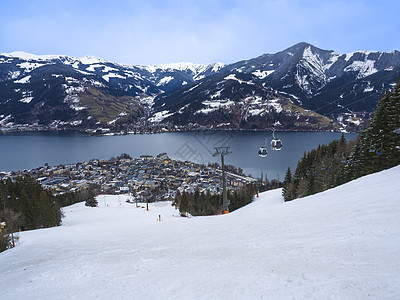 阿尔卑斯山美丽的冬景全景 清澈的湖泊 雪坡 缆车滑雪缆车小屋和村庄中的传统高山小屋 晴天 蓝天 滨湖采尔 萨尔茨堡州 奥地利图片