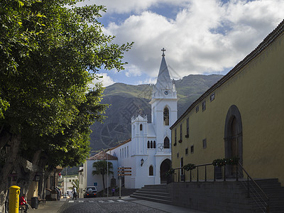 西班牙 加那利群岛 捷内里费 洛斯西洛斯 2017年12月19日 白教堂和古老村庄历史建筑 背景有绿树和山丘图片