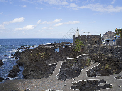 对Garachico村的海池 熔岩岩岩石和主路及加固情况进行观察 以蓝色天空白云背景在Tenerife峡谷岛西班牙图片