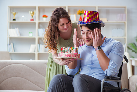 年轻家庭与残疾人一起庆祝生日的年青家庭 夫妻图片