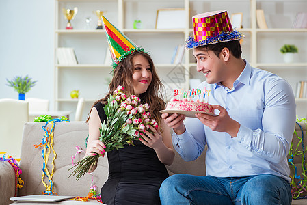 年轻情侣用蛋糕庆祝生日 花束 家庭 惊喜 周年纪念日图片