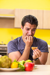 男人在健康食品和不健康食品之间有艰难的选择 假期 饼干图片