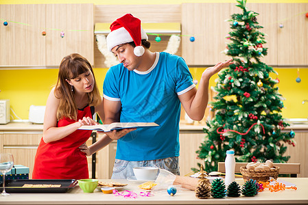饼干在厨房庆祝圣诞节的年轻情侣 派对 展示 书 讨论背景