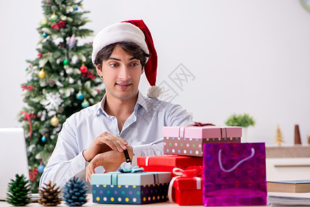 年轻在职雇员在办公室工作的商人的圣诞节概念 乐趣 商业图片